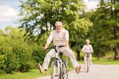 Senior man riding a bike in the park on Labor Day weekend
